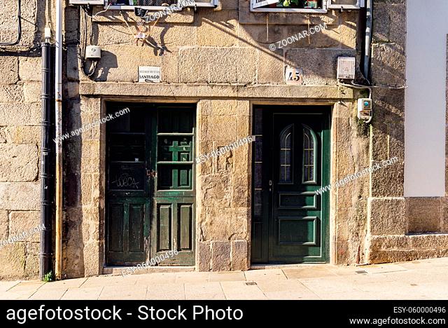 Santiago de Compostela, Spain - July 18, 2020: Old house with green wooden doors in medieval town
