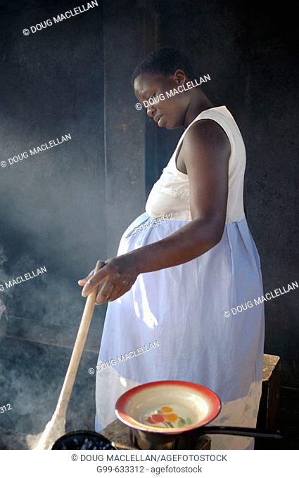 A pregnant woman cooks sadza on an outdoor fire at the Howard Hospital Antenatal Ward (also known as the Women's Shelter) in Zimbabwe