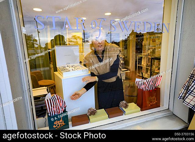 Stockholm, Sweden A woman shop clerk stands in the window of a design store in Vaxholm called Star of Sweden
