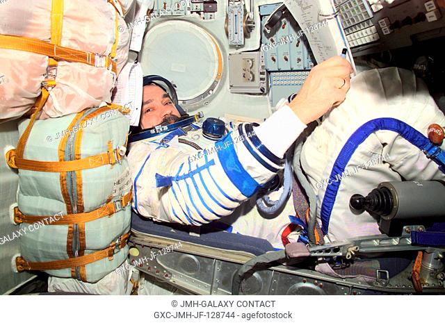Cosmonaut Mikhail Tyurin, Expedition Three flight engineer, wearing a Russian Sokol suit, is seated in the Soyuz spacecraft that is docked to the International...