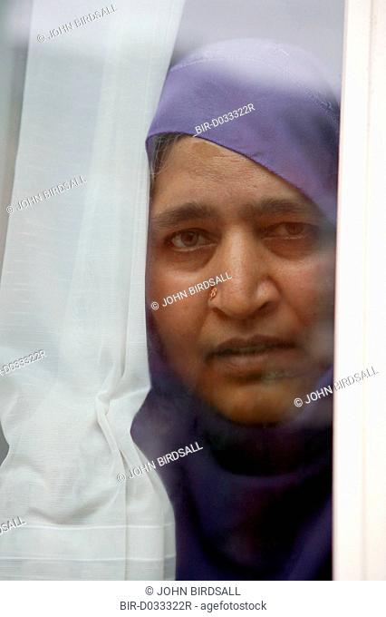 South Asian woman looking out of window