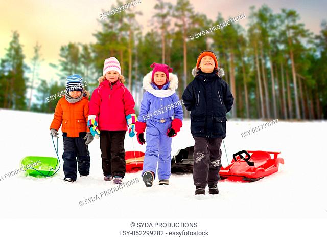 happy little kids with sleds in winter