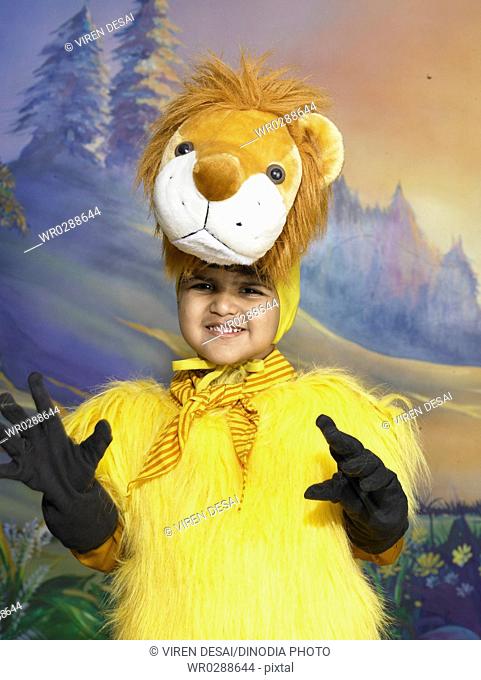 South Asian Indian boy dressed as lion performing fancy dress competition on stage in nursery school MR