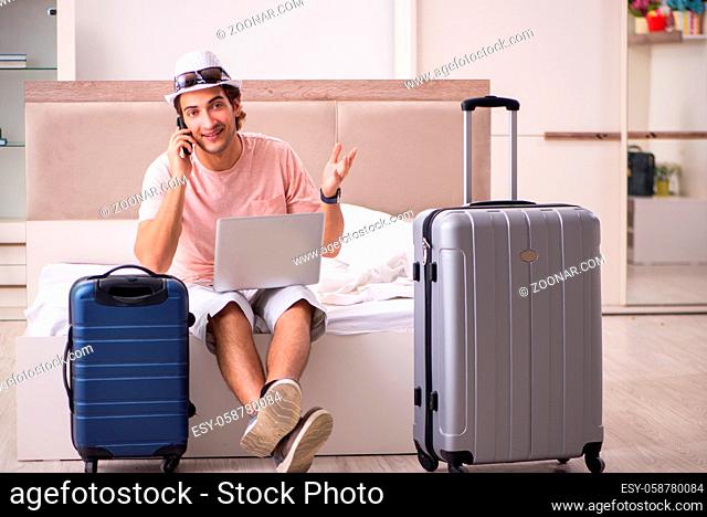 Man with suitcase in bedroom waiting for trip