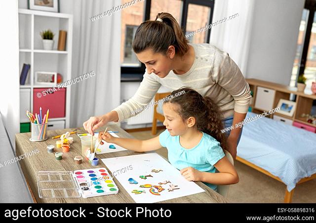 mother with little daughter drawing at home
