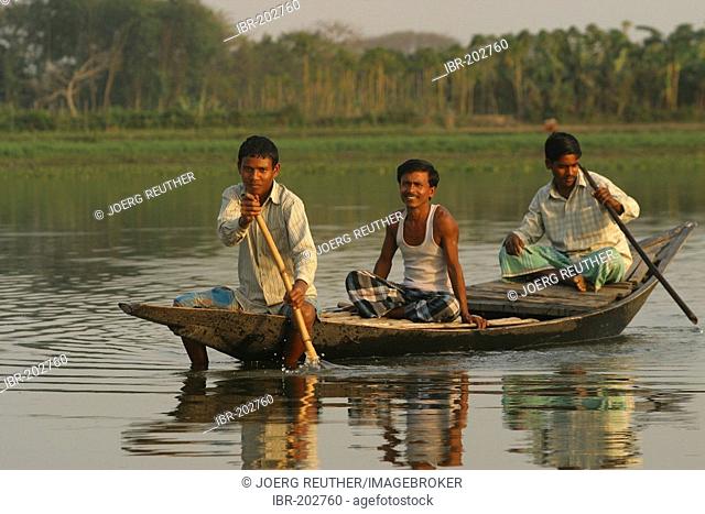 Indian men paddling in a canoe on a river at the Ganges delta, Westbengalia, India