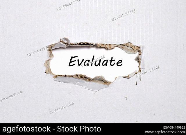 The word evaluate appearing behind torn paper