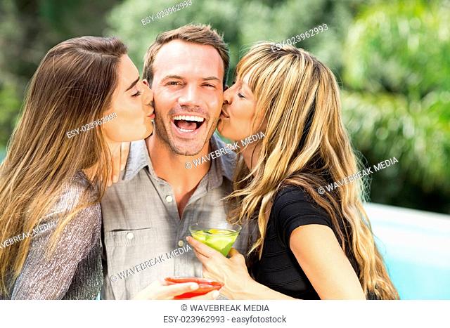 Beautiful women kissing happy man