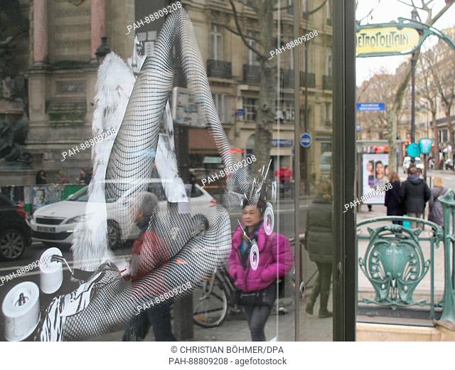 An advertisement poster of French luxury fashion brand Saint Laurent shows a woman with spread legs in fishnet stockings on Boulevard Saint-Michel in Paris