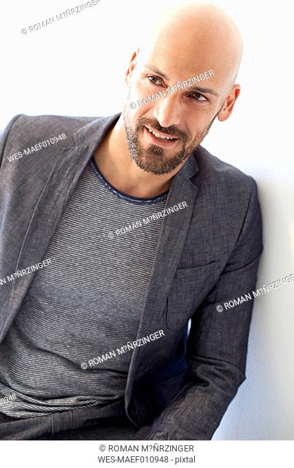 Portrait of bald man wearing grey suit