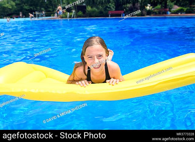Girl on an airbed at an open-air bath