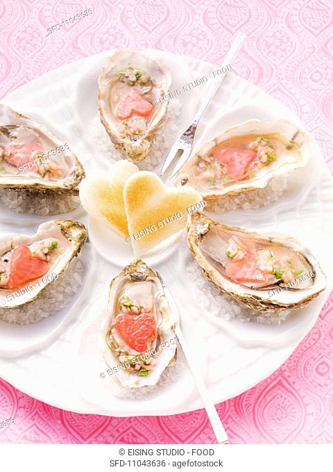 Fresh oysters on a plate of sea salt with heart-shaped toast