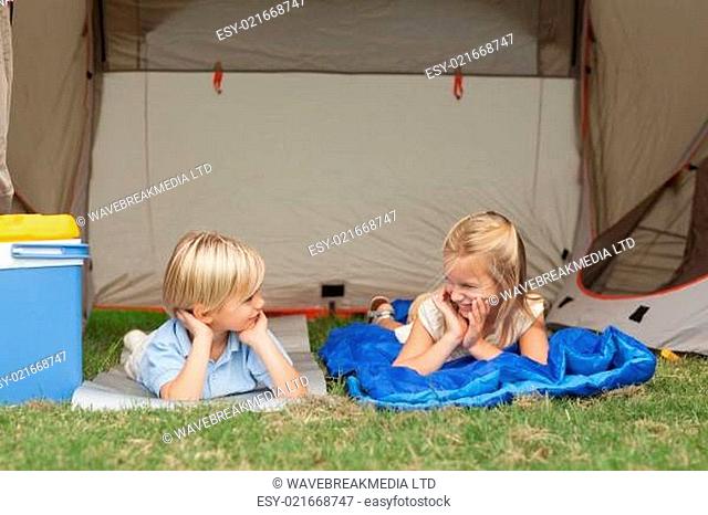Brother and sister talking on the campsite under the tent