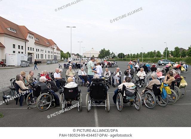 24 May 2018, Germany, Dresden: Residents effected by the evacuation in Dresden sitting during morning gymanstics at the site of the Dresden messe in an...