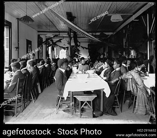 Interior view of dining hall, decorated for the holidays, with students.. Tuskegee Institute, c1902 Creator: Frances Benjamin Johnston