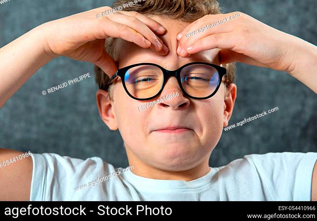 a boy with glasses has a headache