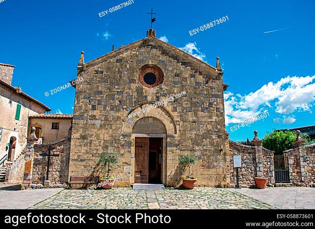 Facade view of an old church in a sunny day at the hamlet of Monteriggioni. A medieval fortress, surrounded by stone walls, at the top of a hill, near Siena