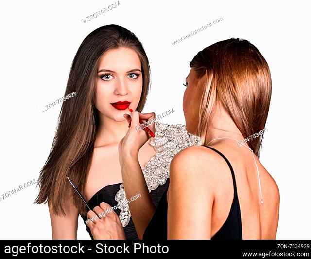 Make-up artist applying lip liner on model#39;s lips on the white background