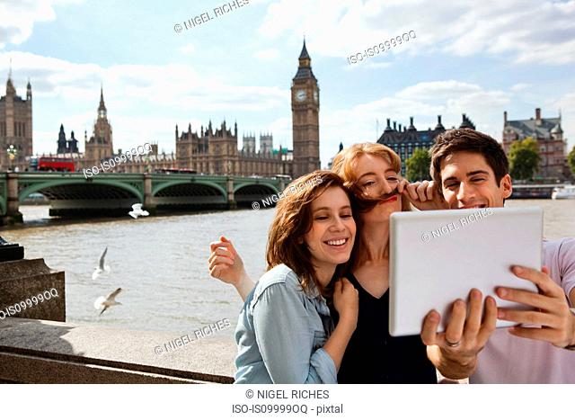 Friends using a digital tablet in central London