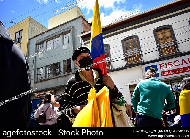 Senior man working as a street vendor offers Colombian flags for sale for protesters who are on the street in Pasto, Narino, Colombia on May 14, 2021