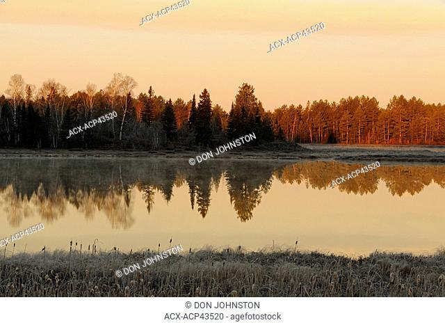 Reflections in a small lake at dawn, Lively, Greater Sudbury, Ontario, Canada