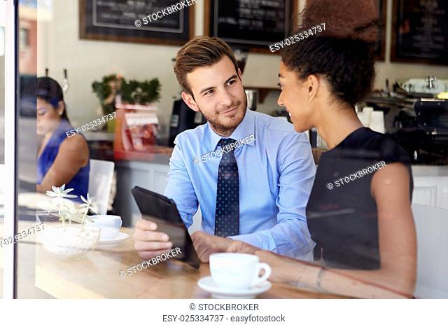 Businessman And Businesswoman Meeting In Coffee Shop