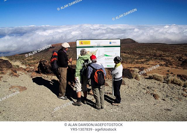 Group of walkers reading imformation board on footpath to the summit of El Teide on Tenerife in the Canary Islands, Spain