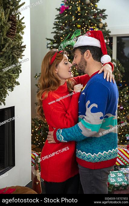Tender couple embracing each other in front of Christmas tree