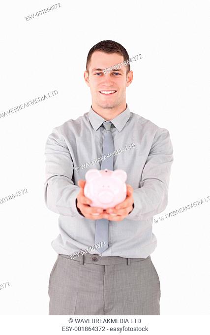 Portrait of a businessman holding a piggy bank against a white background