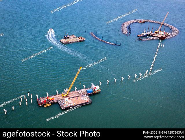PRODUCTION - 10 August 2023, Mecklenburg-Western Pomerania, Prerow: Cranes standing on pontoons are used to assemble the concrete structures for the new island...