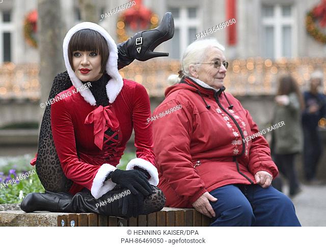 Contortionist Alina Ruppel shows off her skills beside a member of the public on a bench in Cologne, Germany, 12 December 2016