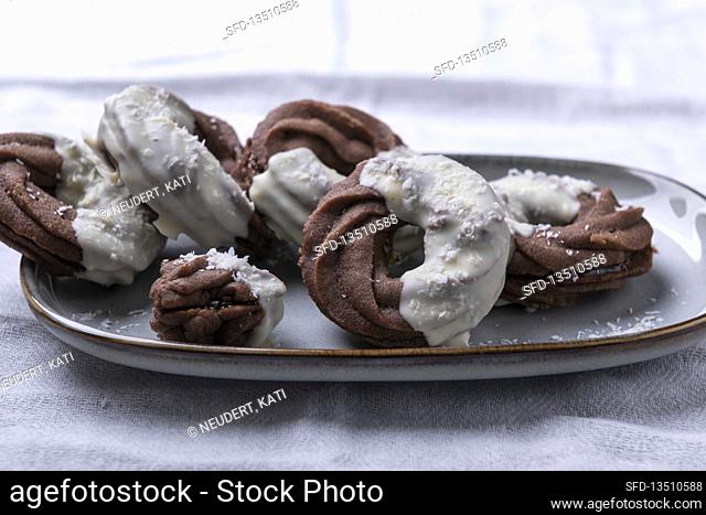 Vegan chocolate sand rings filled with jam, covered with white rice milk chocolate