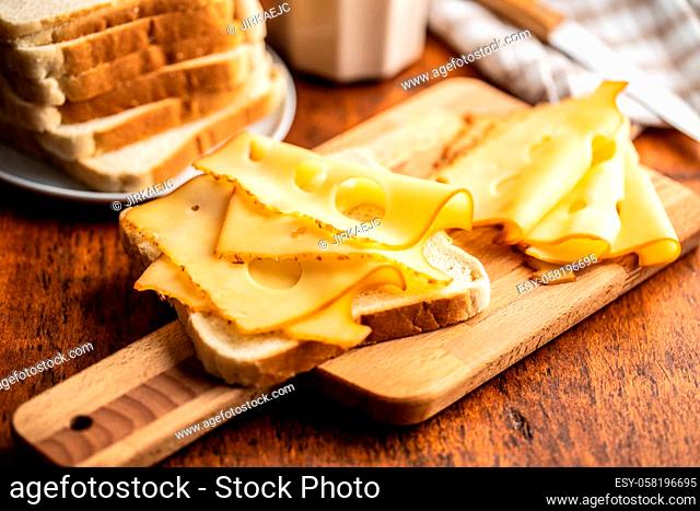 Sandwich bread with hard cheese on cutting board