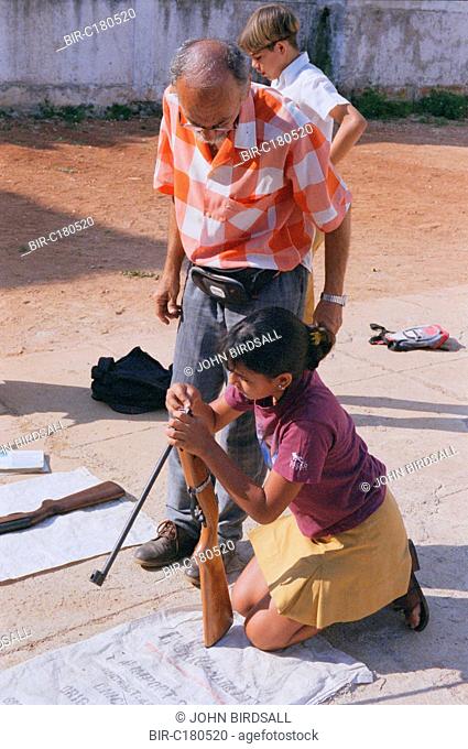 Secondary school girl loading gun during shooting lesson