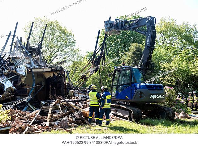 23 May 2019, Schleswig-Holstein, Wohltorf: An excavator from the German Federal Agency for Technical Relief is pulling apart rubble from a house that was...