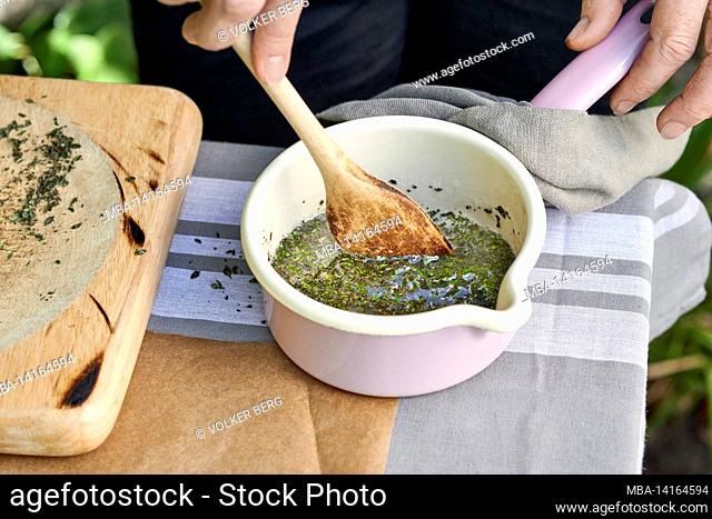 the steps for making thyme candies, a mixture of melted birch sugar and crushed thyme leaves are mixed with a wooden spoon