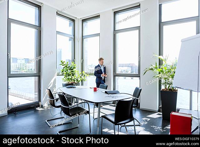 Businessman standing at thw window in office