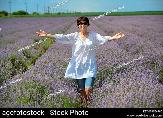 Happy Middle Aged Woman walking in Lavender Field