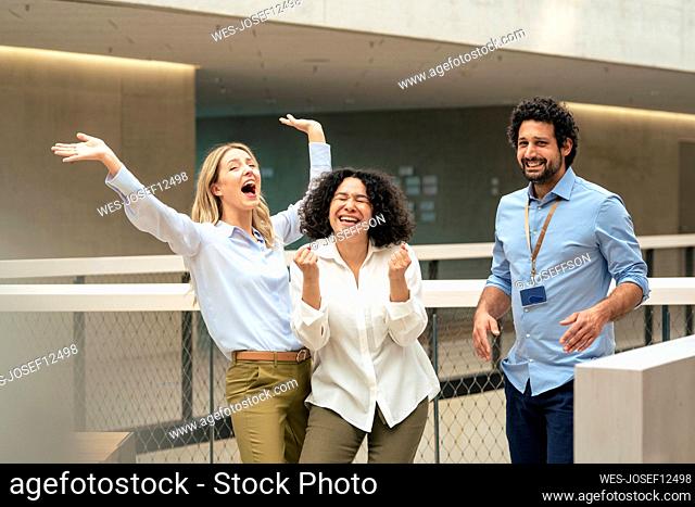 Cheerful business colleagues enjoying in corridor