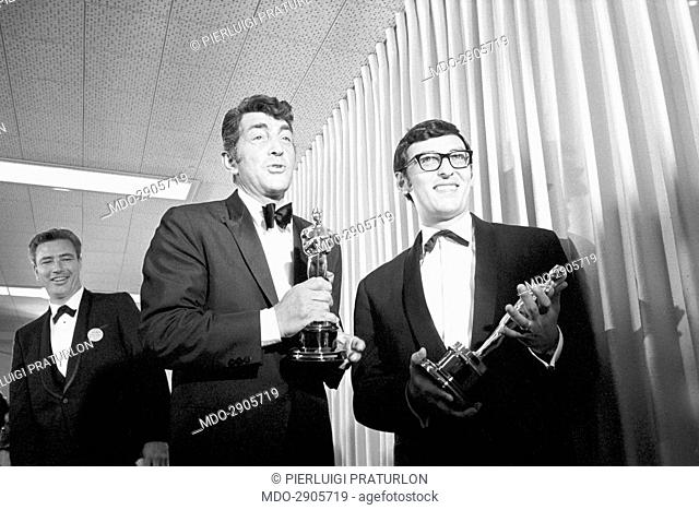 Italian American singer and actor Dean Martin (Dino Paul Crocetti) at the Academy Awards ceremony. Beside him, Don Black english songwriter with Oscar received...