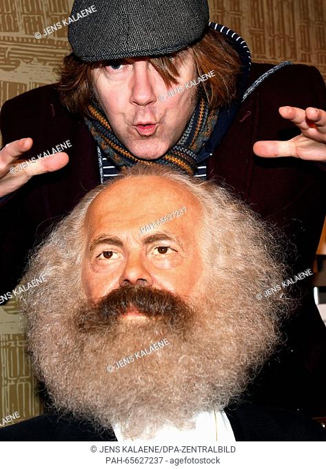 Singer and composer Tobias Kuenzel, known as front man of the German Band 'Die Prinzen' poses with the wax figure of Karl Marx at Madame Tussauds in Berlin