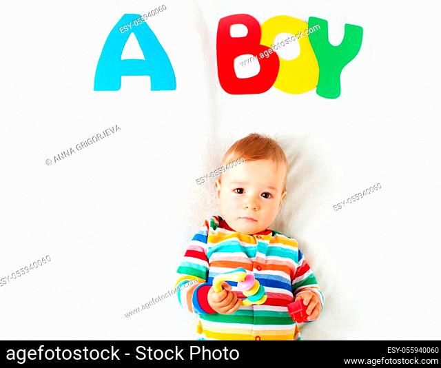 Baby boy lying on soft blanket with letters above