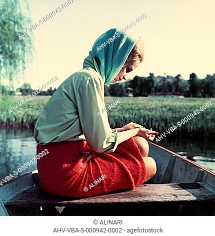 Young woman sitting on a boat in a thoughtful pose