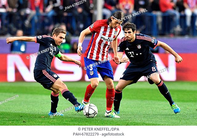 Munich's Philipp Lahm (L) and Javier 'Javi' Martinez and Madrid's Filipe Luis vie for the ball during the Champions League semi-final match between Atletico...