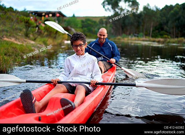 Portrait happy father and son kayaking on river