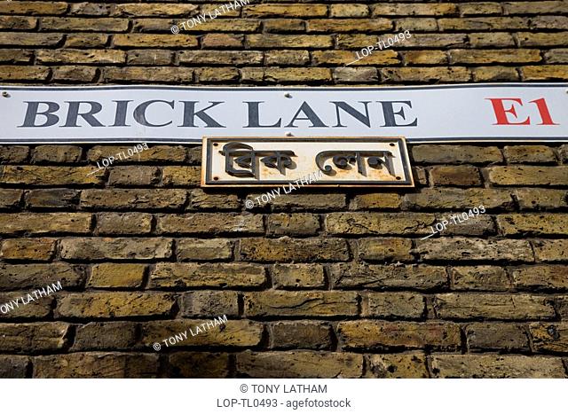 England, London, Brick Lane, Looking up to the Brick Lane street sign on a brick wall in East London