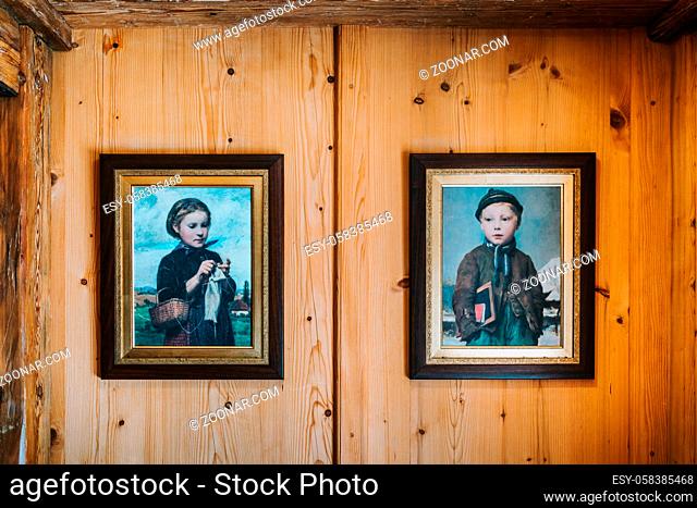 photo of vintage paintings on a wooden wall of a boy and a girl