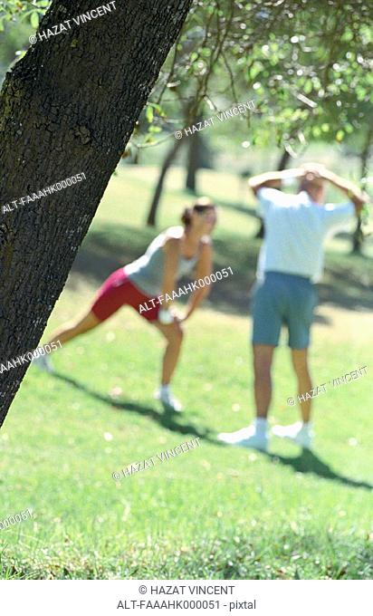 Couple stretching in park