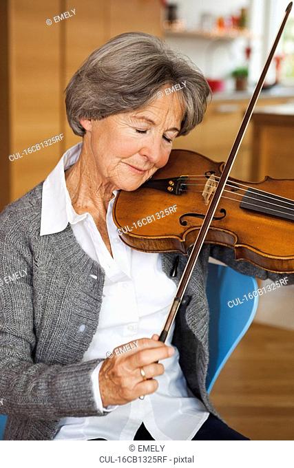 old woman tuning violin