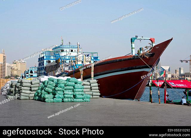 Dubai, United Arab Emirates - March 24, 2018. The reverse side of the seaport. A small private no name merchant ship unloads bags with cotton on the berth